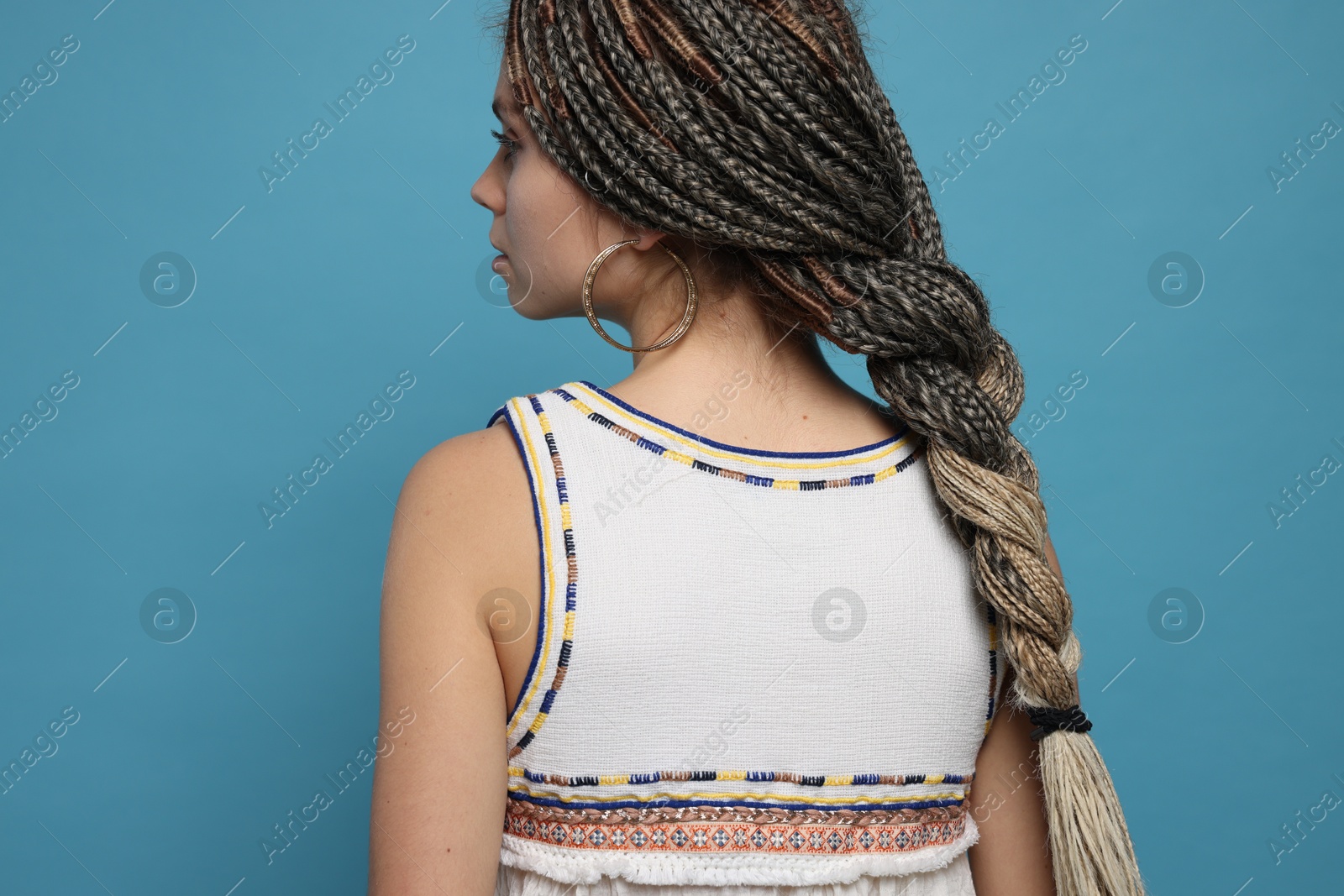 Photo of Beautiful woman with long african braids on blue background