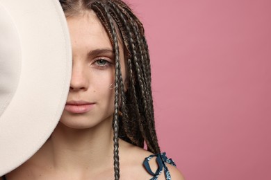 Photo of Beautiful woman with long african braids on pink background, space for text