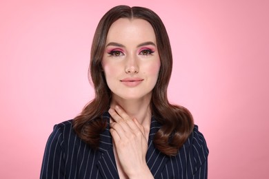 Photo of Portrait of beautiful young woman with stylish makeup and gorgeous hair on pink background