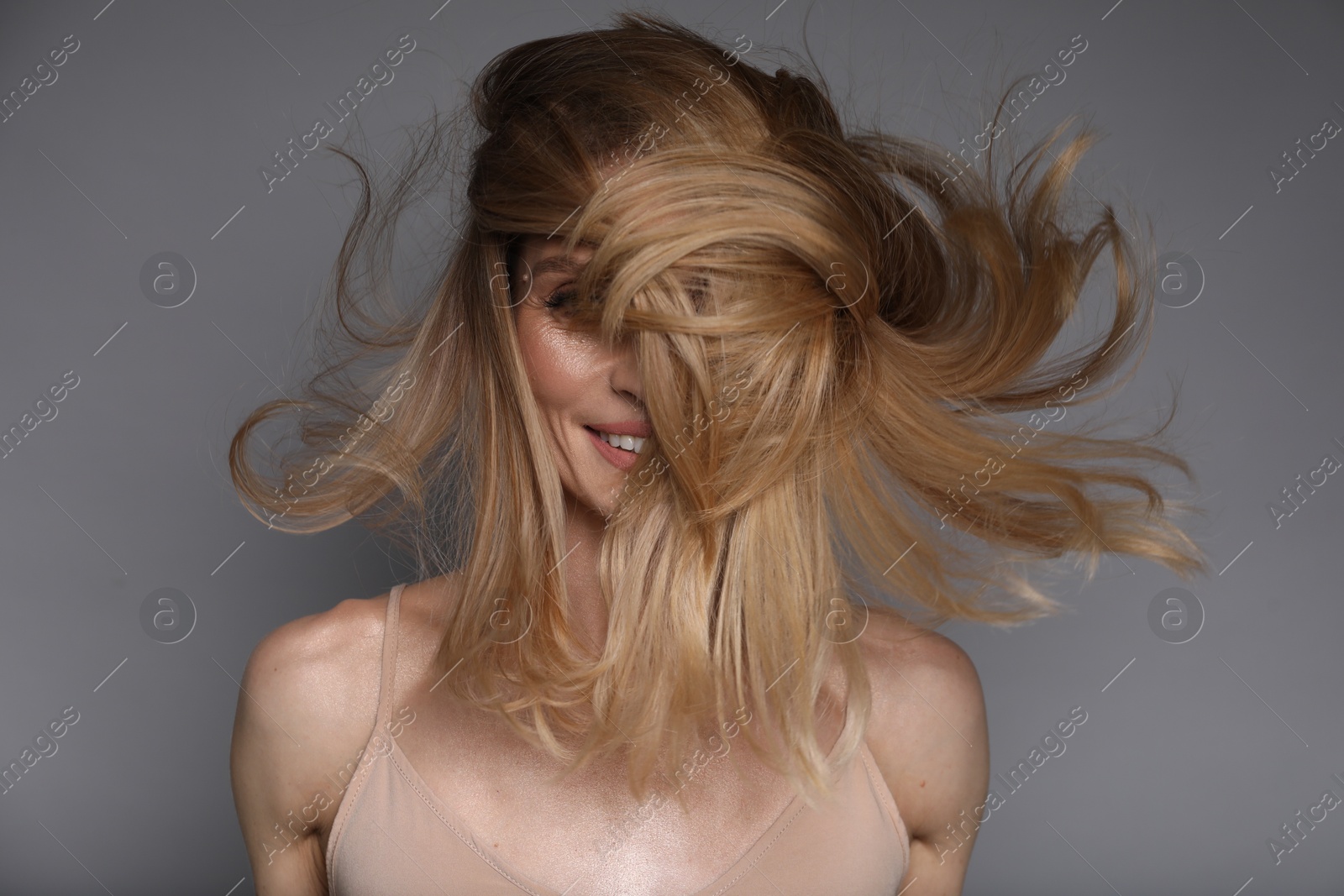 Photo of Woman with beautiful blonde hair on grey background