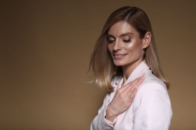 Photo of Portrait of beautiful happy woman with straight blonde hair on light brown background, space for text