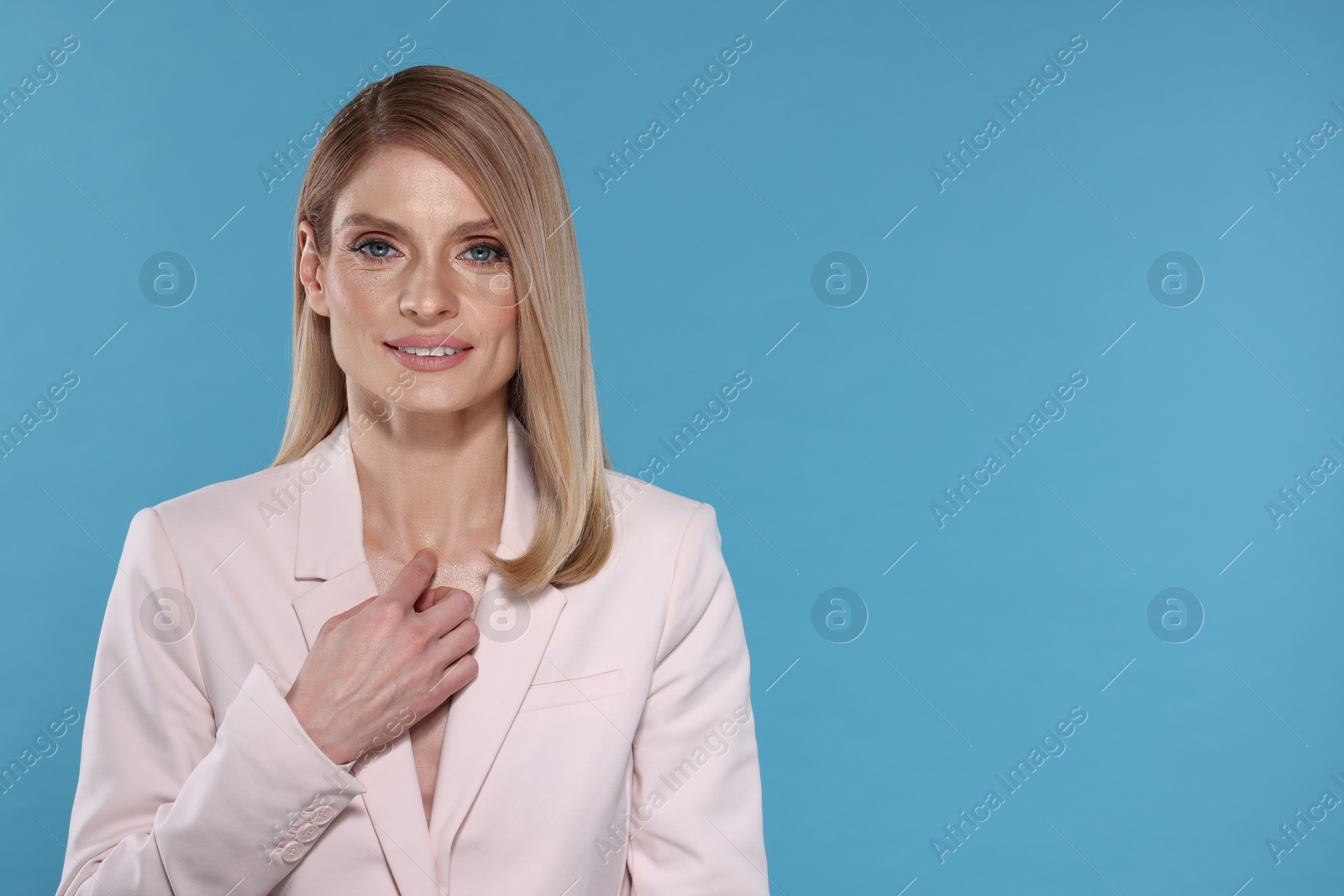 Photo of Beautiful happy woman with straight blonde hair on light blue background, space for text