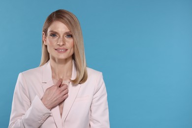 Photo of Beautiful happy woman with straight blonde hair on light blue background, space for text