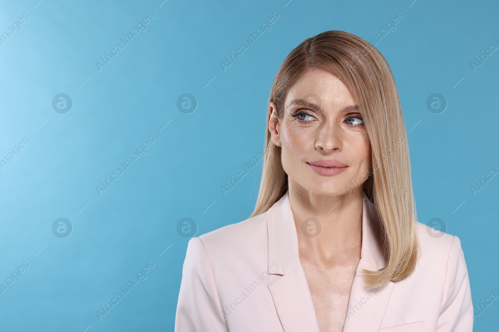 Photo of Portrait of beautiful woman with straight blonde hair on light blue background. Space for text