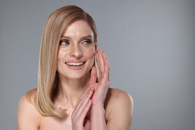 Photo of Portrait of beautiful happy woman with straight blonde hair on grey background. Space for text