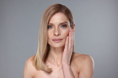 Photo of Portrait of beautiful woman with straight blonde hair on grey background