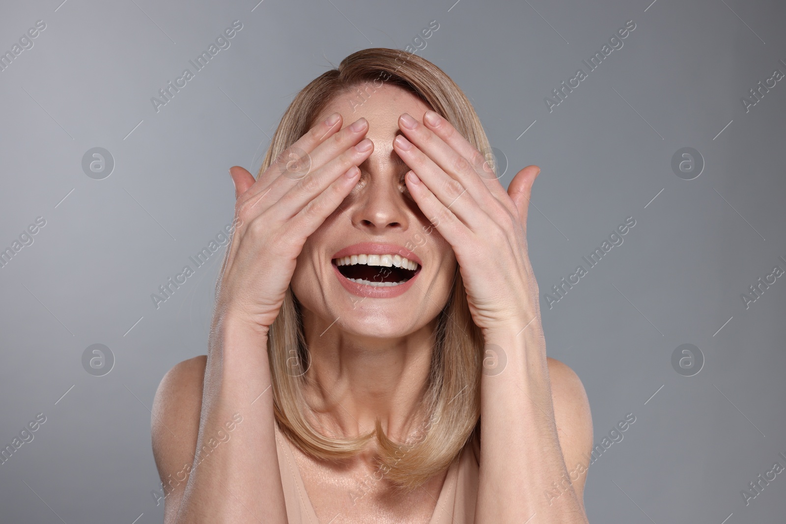 Photo of Happy smiling woman with straight blonde hair on light grey background