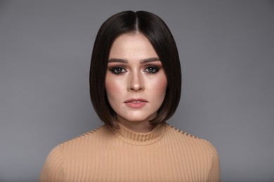 Photo of Portrait of beautiful young woman with gorgeous straight hair on grey background