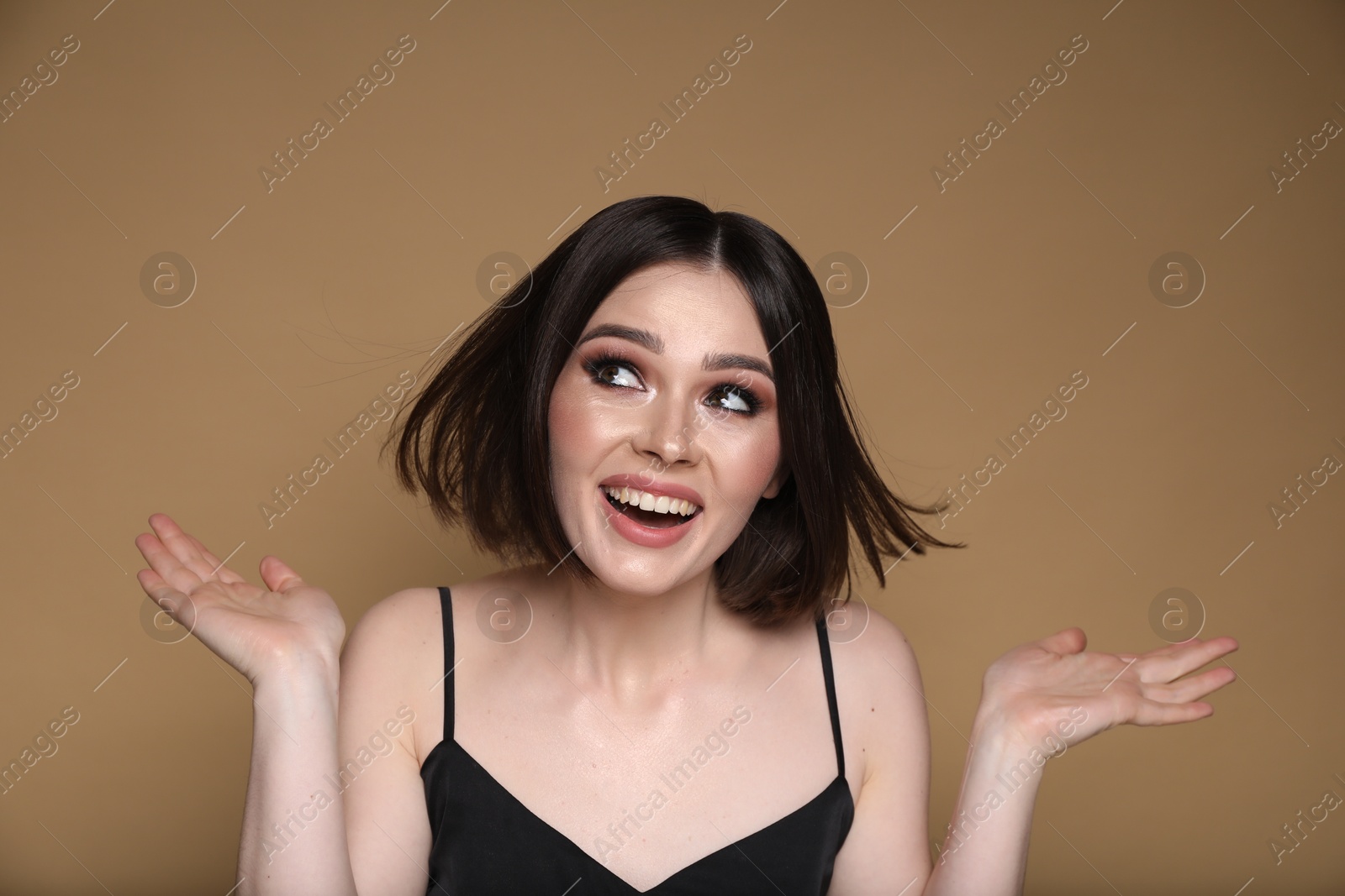 Photo of Portrait of beautiful young happy woman with gorgeous straight hair on dark beige background