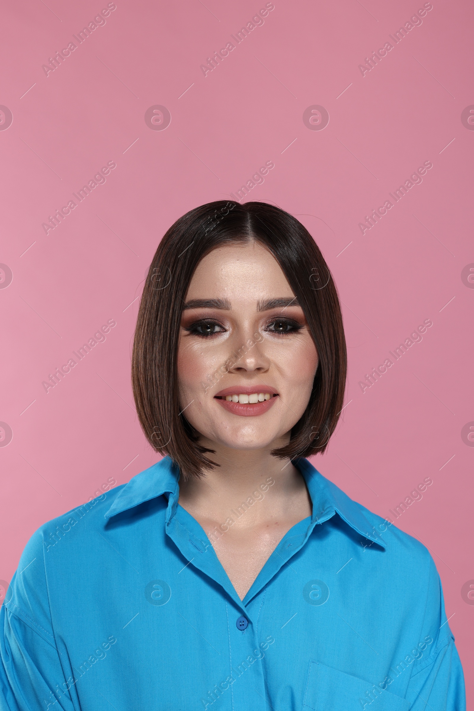 Photo of Portrait of beautiful young happy woman with gorgeous straight hair on pink background