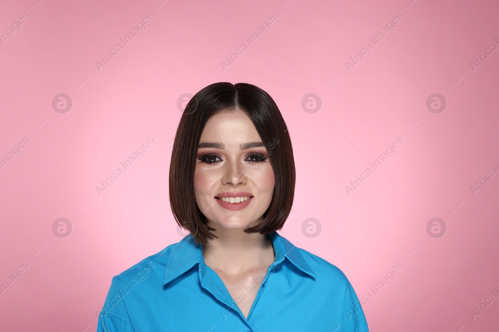 Photo of Portrait of beautiful young happy woman with gorgeous straight hair on pink background