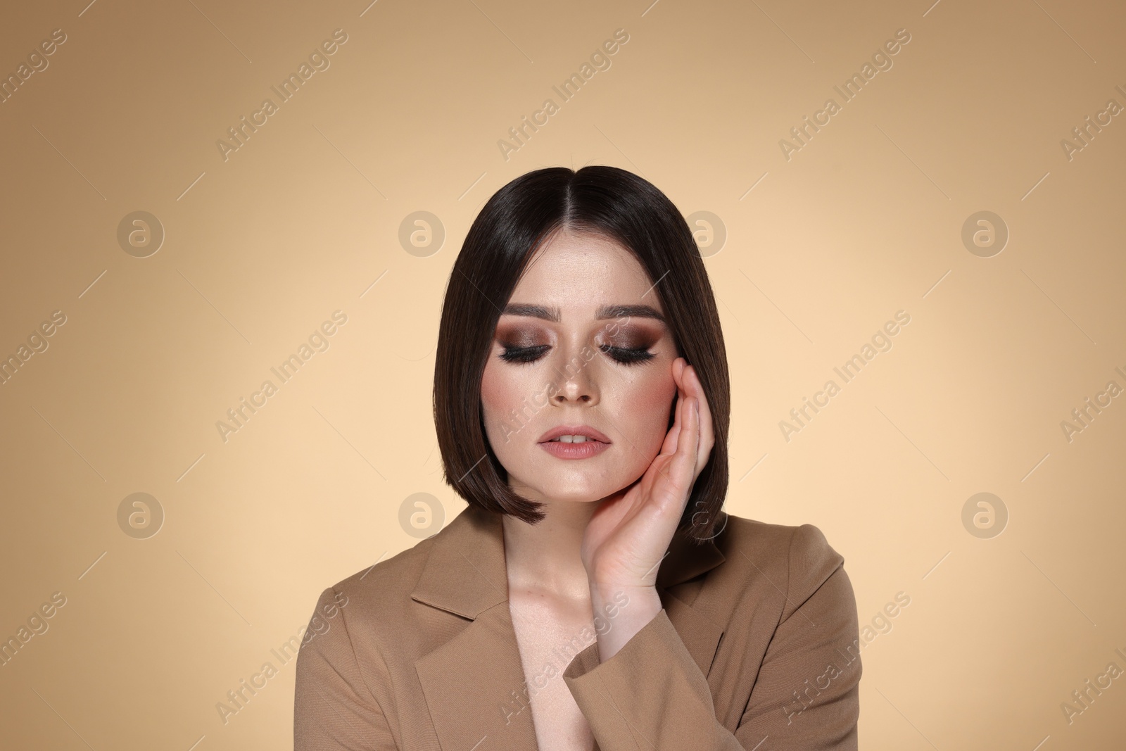 Photo of Portrait of beautiful young woman with gorgeous straight hair and stylish makeup on beige background