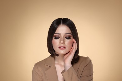 Photo of Portrait of beautiful young woman with gorgeous straight hair and stylish makeup on beige background