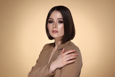 Photo of Portrait of beautiful young woman with gorgeous straight hair on beige background