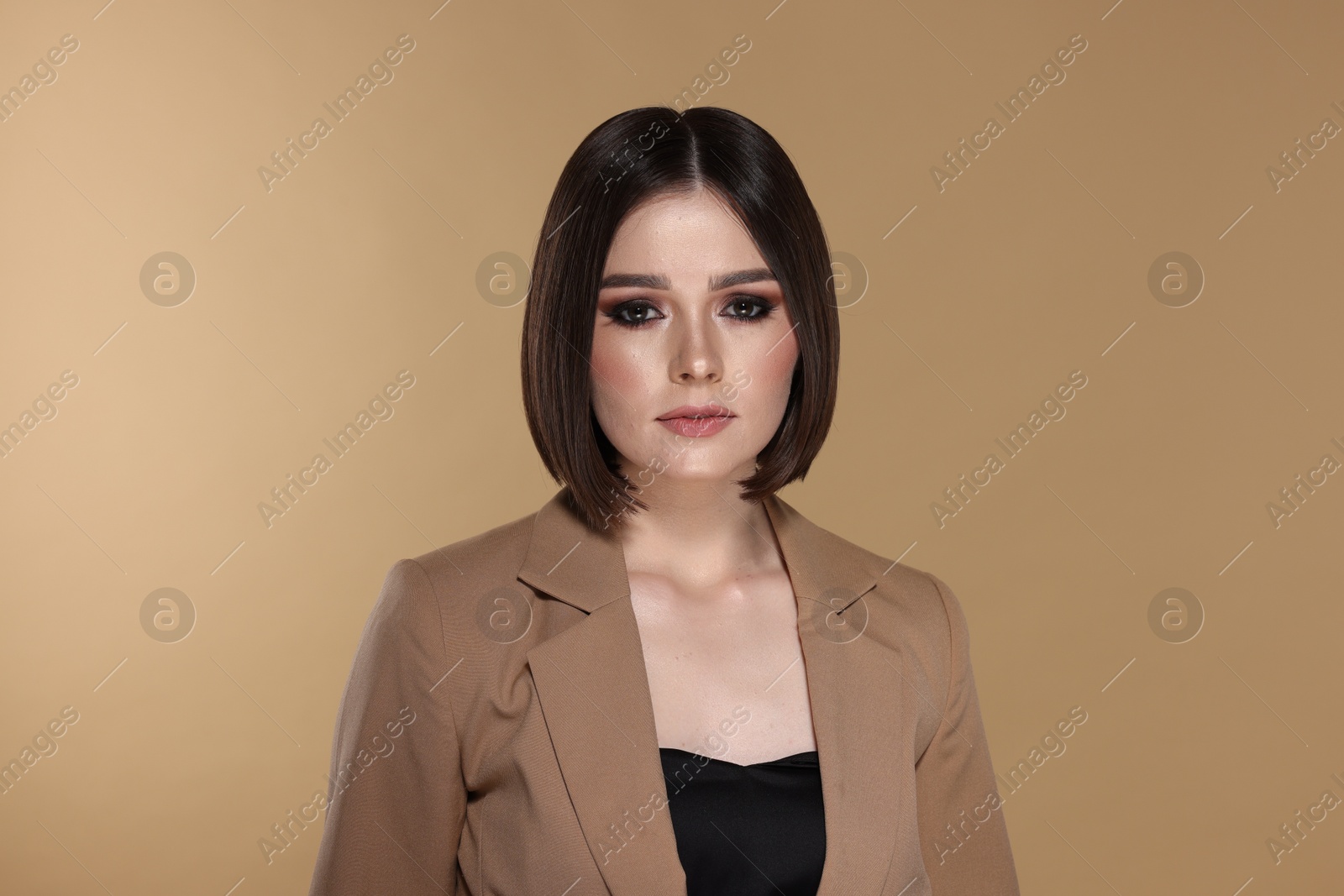 Photo of Portrait of beautiful young woman with gorgeous straight hair on beige background