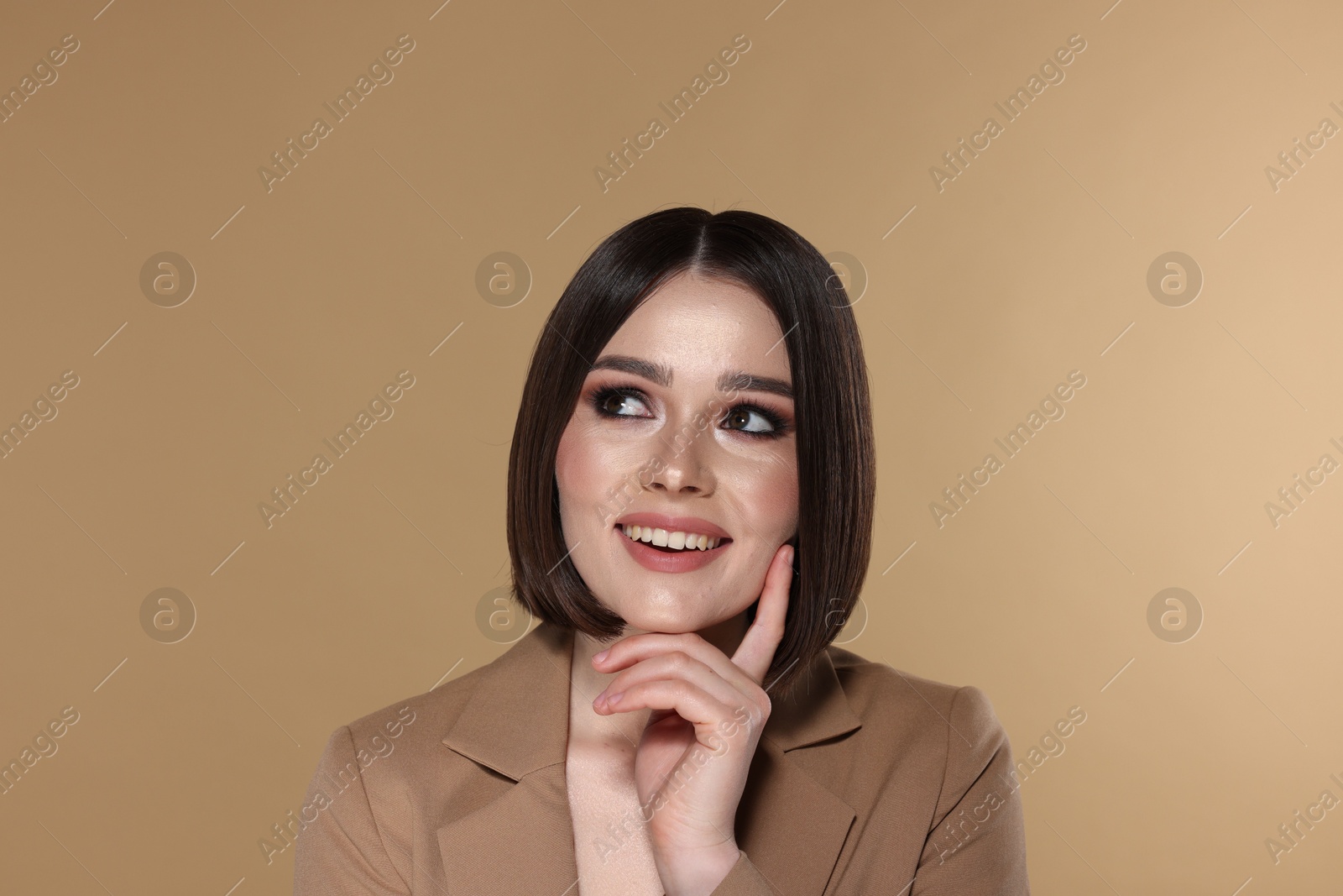 Photo of Portrait of beautiful young happy woman with gorgeous straight hair on beige background