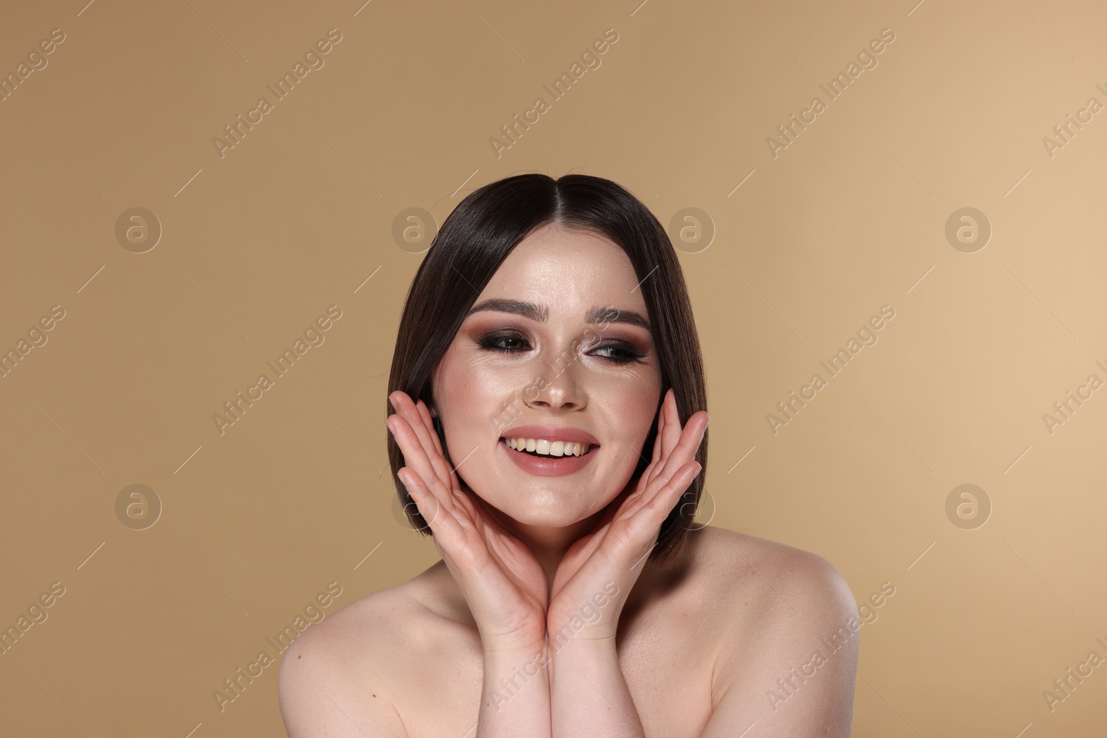 Photo of Portrait of beautiful young happy woman with gorgeous straight hair on beige background