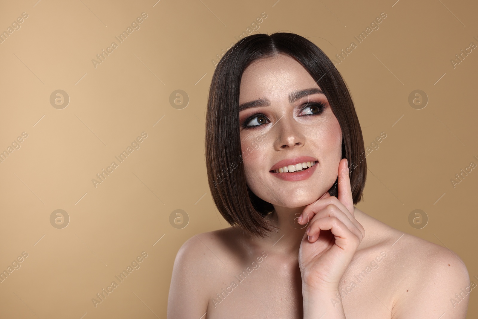 Photo of Portrait of beautiful young happy woman with gorgeous straight hair on beige background, space for text