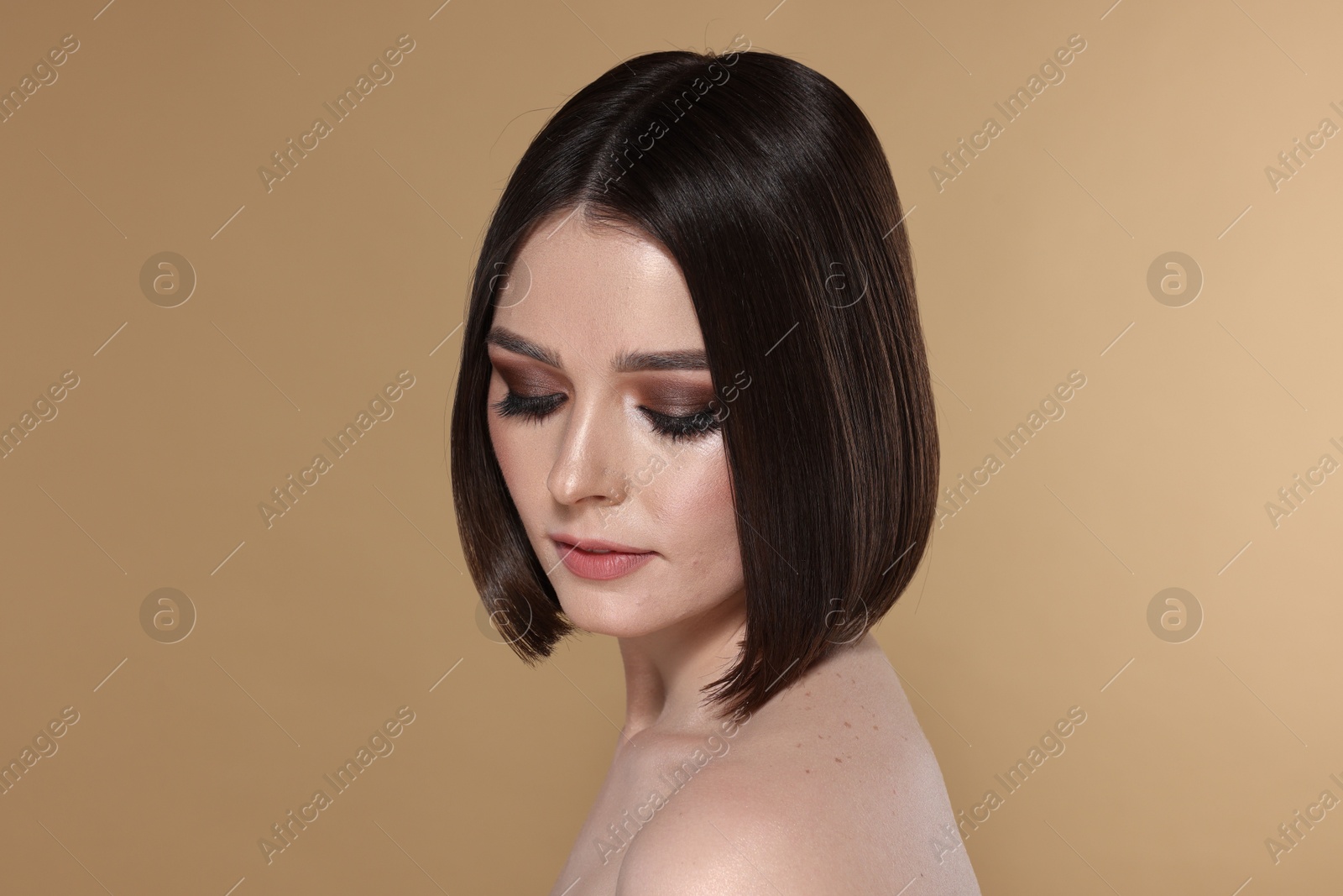 Photo of Portrait of beautiful young woman with gorgeous straight hair and stylish makeup on beige background