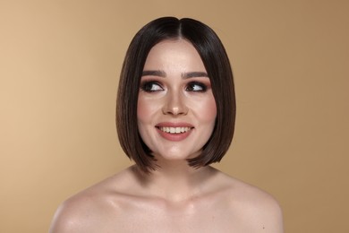 Photo of Portrait of beautiful young happy woman with gorgeous straight hair on beige background