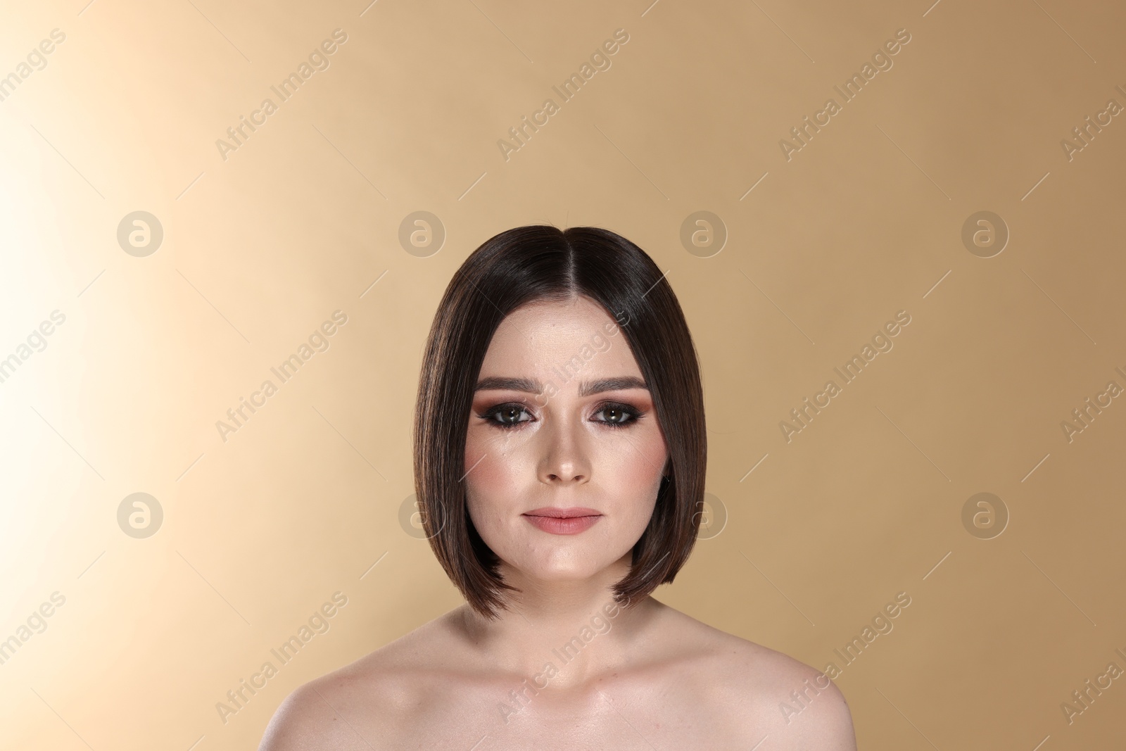 Photo of Portrait of beautiful young woman with gorgeous straight hair on beige background