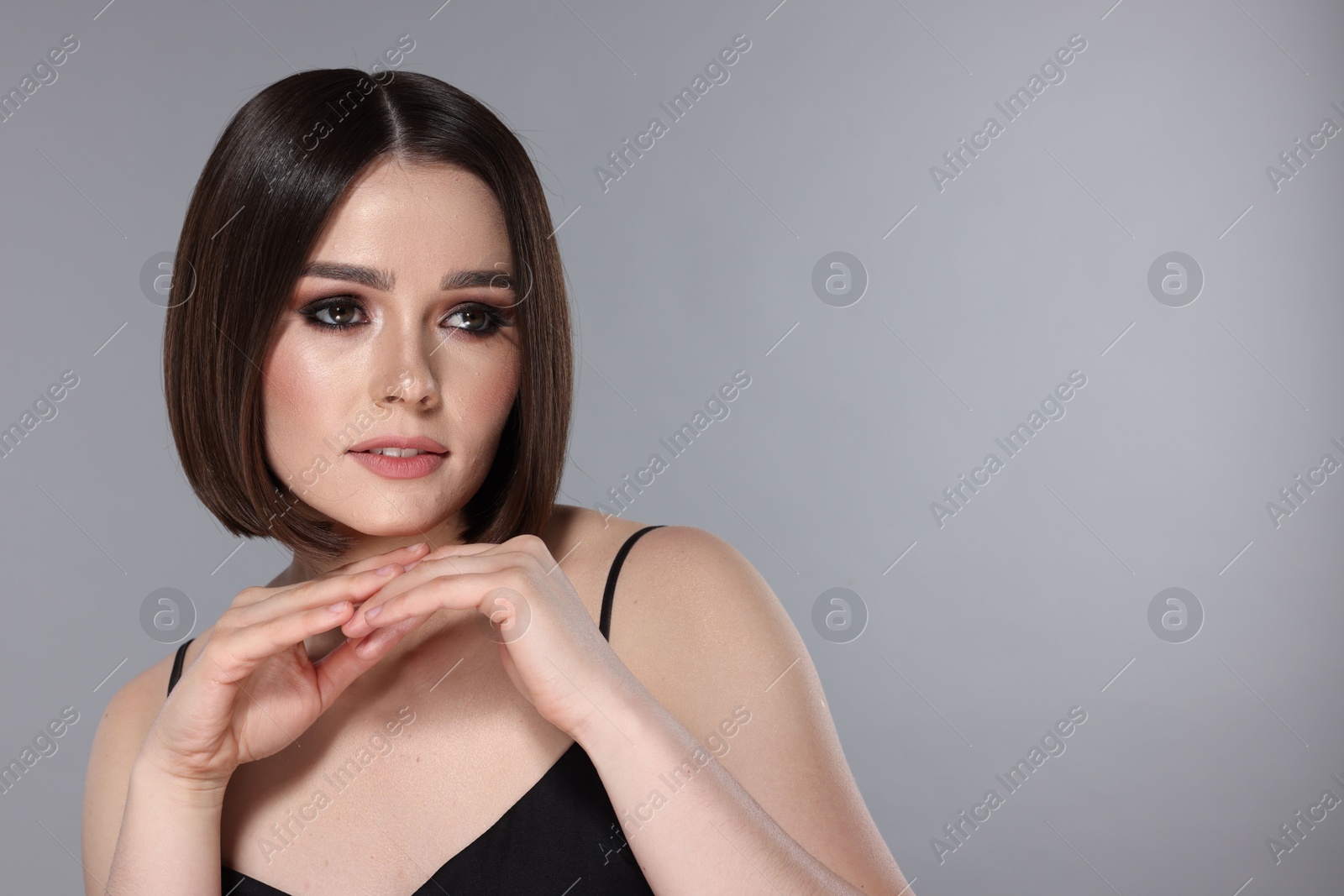 Photo of Portrait of beautiful young woman with gorgeous straight hair on light grey background, space for text