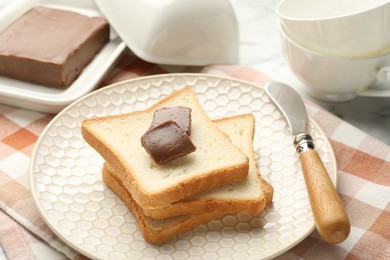 Sandwiches with chocolate butter and knife on table, closeup