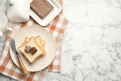 Photo of Sandwiches with chocolate butter and knife on white marble table, flat lay. Space for text