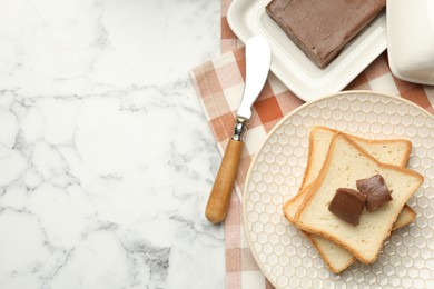 Photo of Sandwiches with chocolate butter and knife on white marble table, flat lay. Space for text