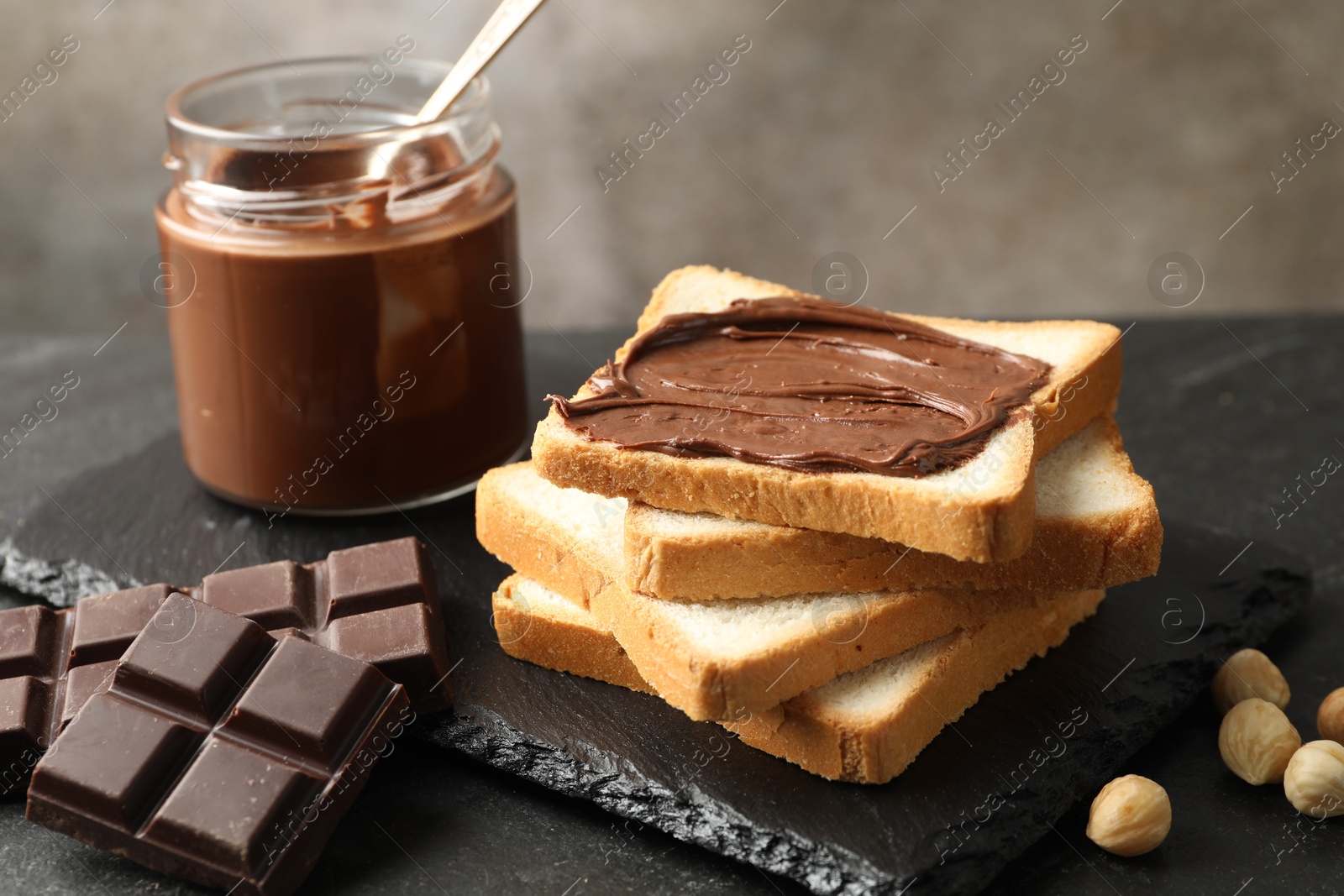 Photo of Sandwich with chocolate butter and hazelnuts on table, closeup