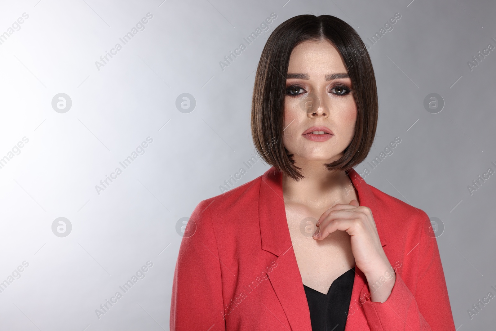 Photo of Portrait of beautiful young woman with gorgeous straight hair on light grey background, space for text