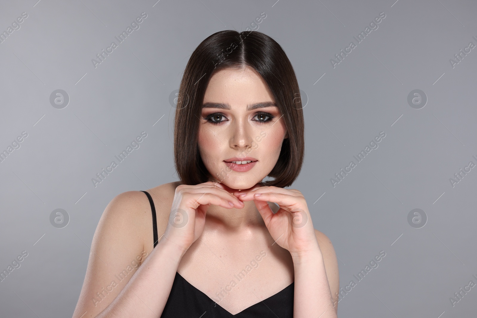 Photo of Portrait of beautiful young woman with gorgeous straight hair on light grey background