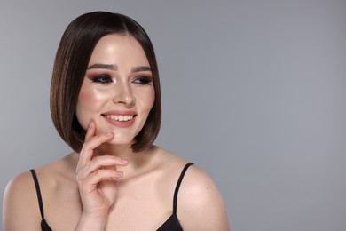 Photo of Portrait of beautiful young happy woman with gorgeous straight hair on light grey background, space for text