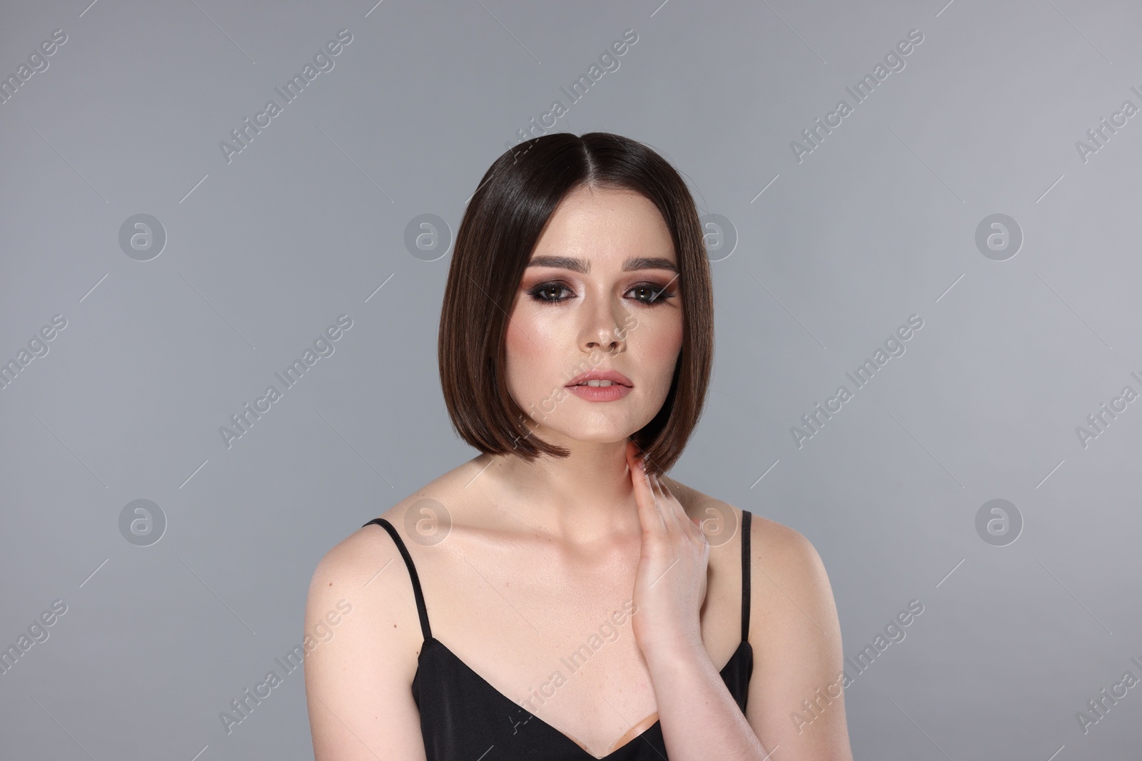 Photo of Portrait of beautiful young woman with gorgeous straight hair on light grey background