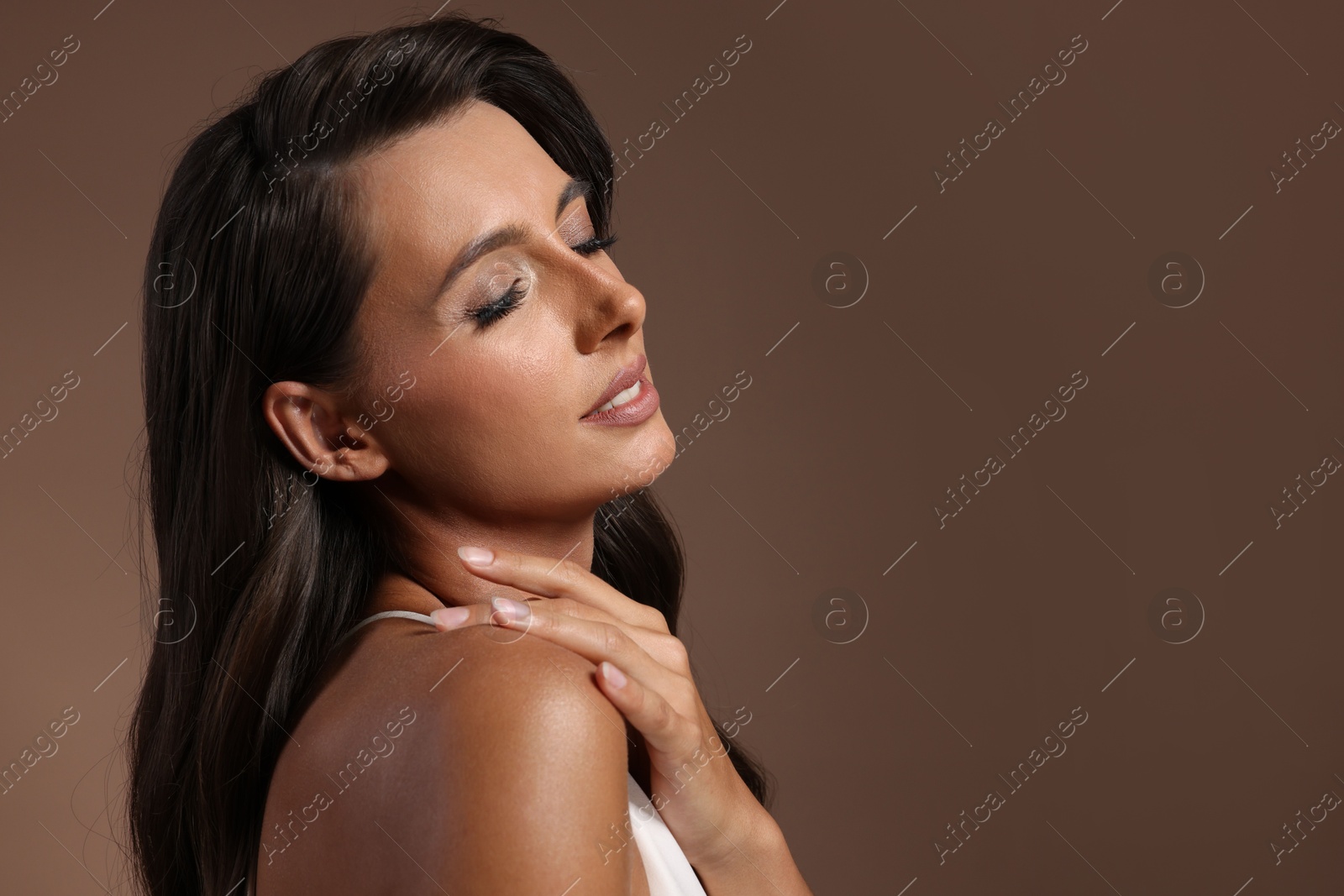 Photo of Hair styling. Beautiful woman with wavy long hair on brown background. Space for text