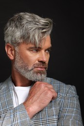 Photo of Portrait of confident man with beautiful hairstyle on black background