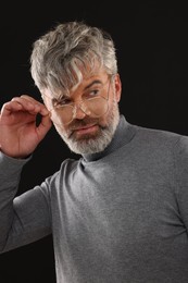 Photo of Portrait of confident man with beautiful hairstyle on black background