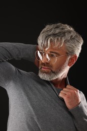 Photo of Portrait of confident man with beautiful hairstyle on black background