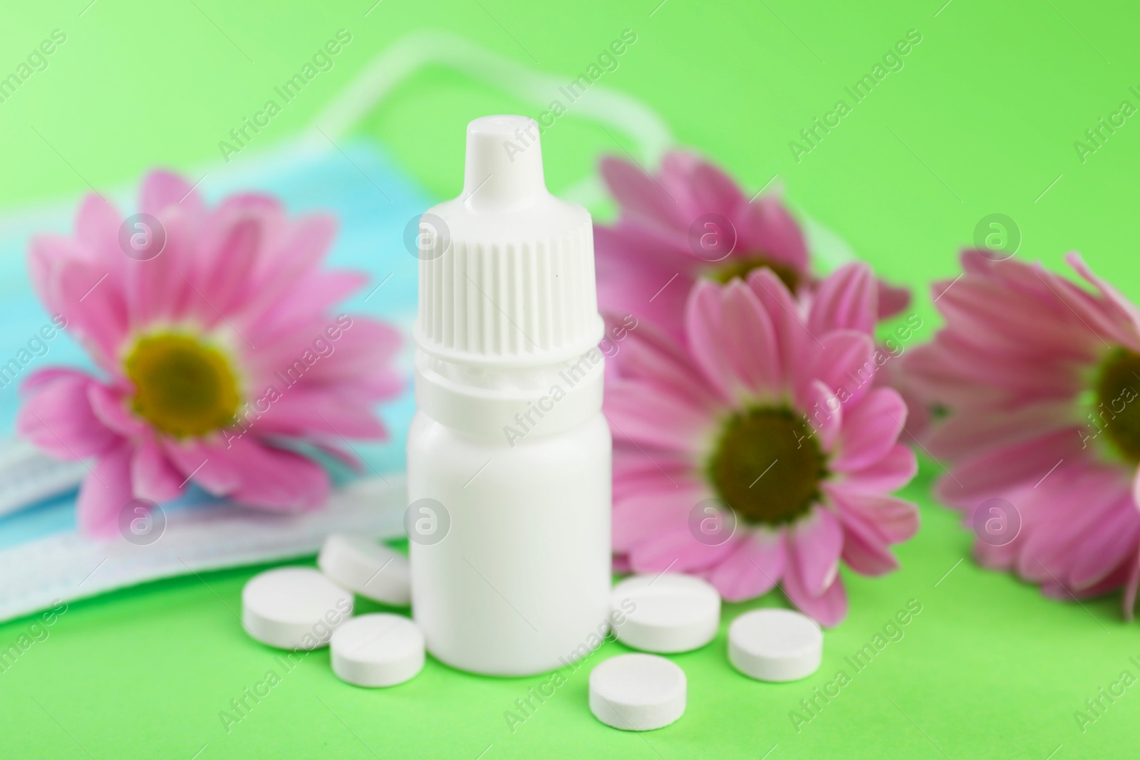 Photo of Allergy treatment. Nasal drops and pills on green background