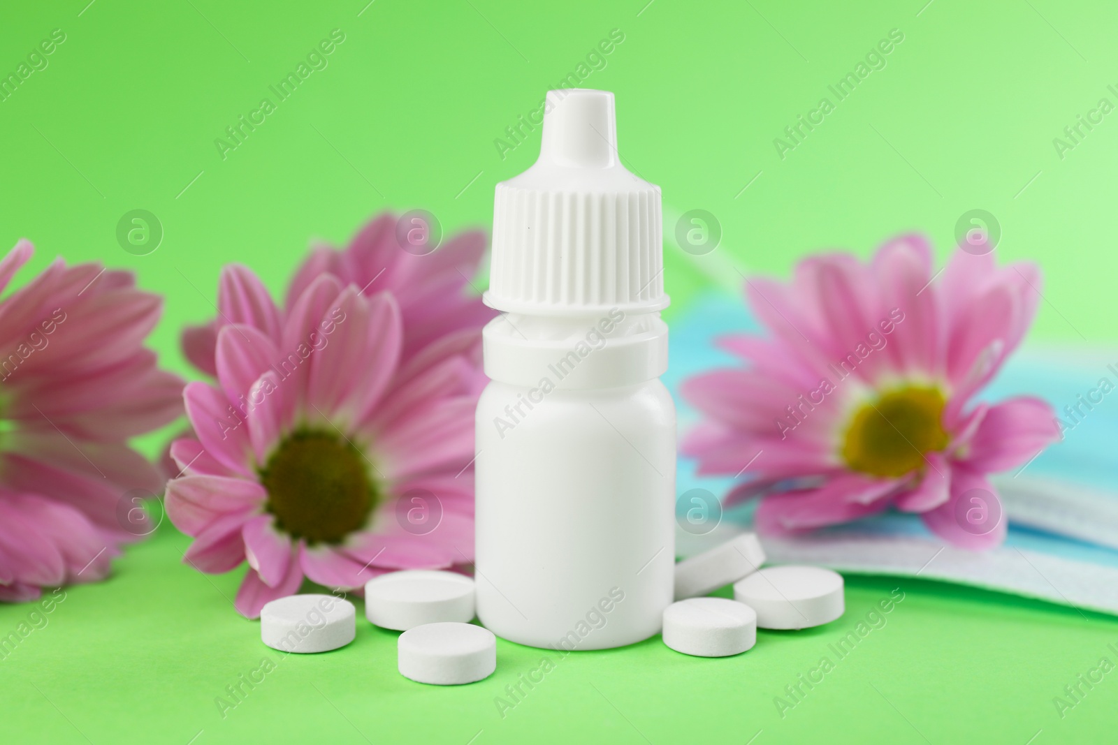 Photo of Allergy treatment. Nasal drops and pills on green background