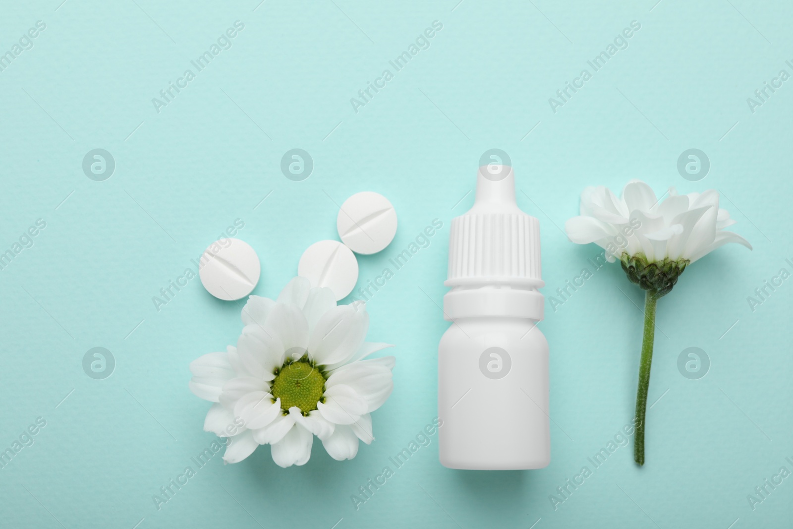 Photo of Allergy treatment. Nasal drops, pills and flowers on light blue background, flat lay. Space for text