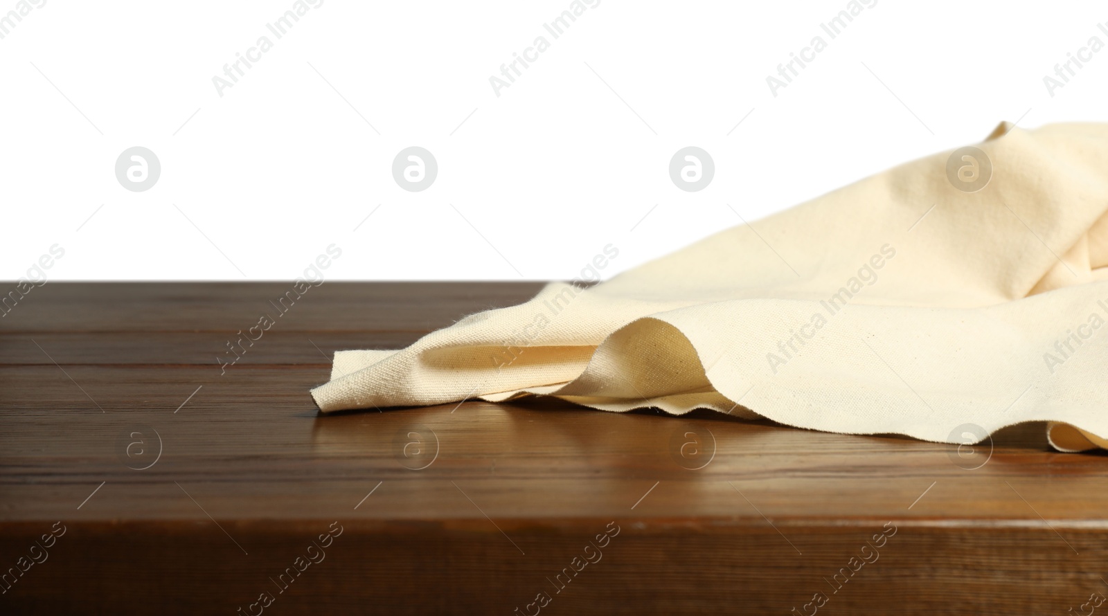 Photo of Beige tablecloth on wooden table against white background, closeup