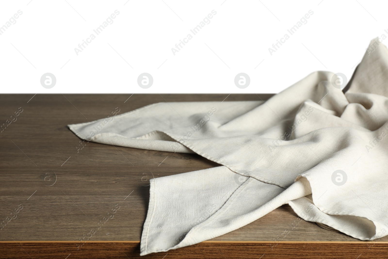 Photo of Light tablecloth on wooden table against white background, closeup