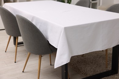 Photo of Table with white tablecloth and chairs indoors