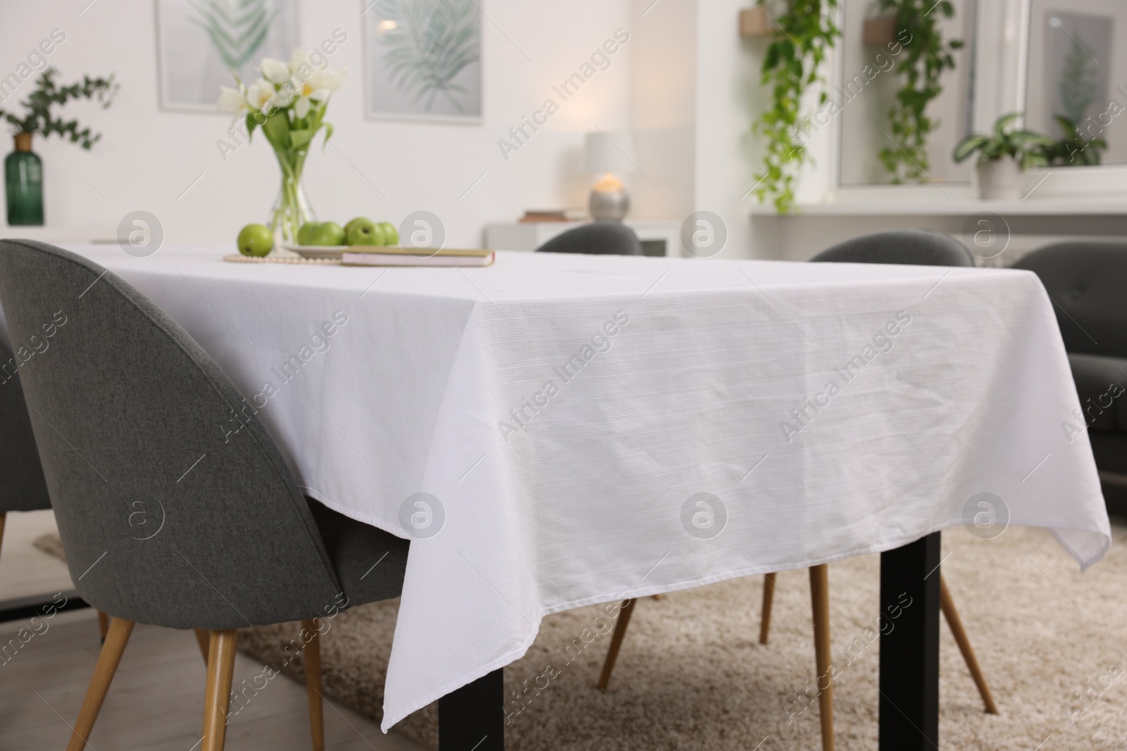 Photo of Table with white tablecloth and chairs indoors, closeup. Interior design