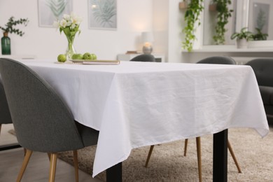 Photo of Table with white tablecloth and chairs indoors, closeup. Interior design