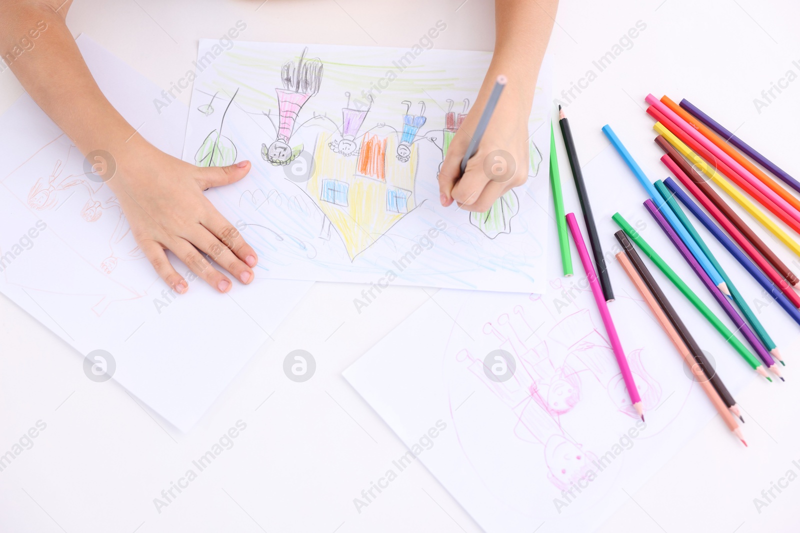 Photo of Boy drawing his family at white table indoors, top view