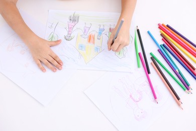 Photo of Boy drawing his family at white table indoors, top view