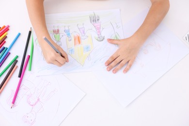 Photo of Boy drawing his family at white table indoors, top view