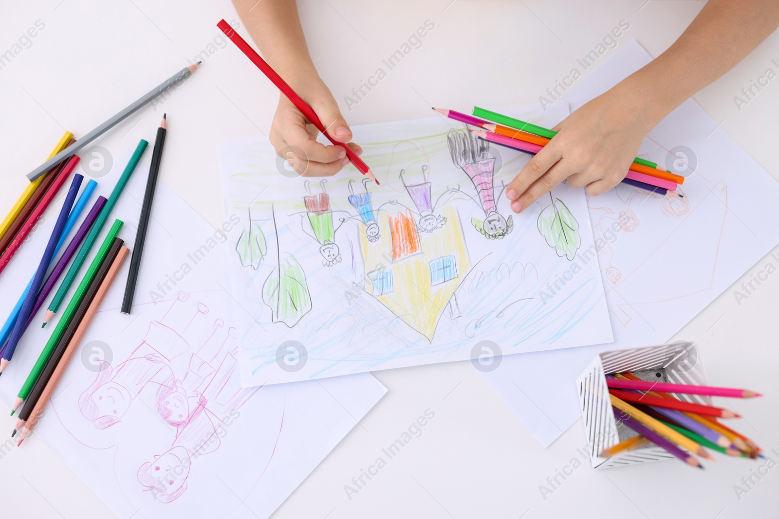 Photo of Boy drawing his family at white table indoors, top view